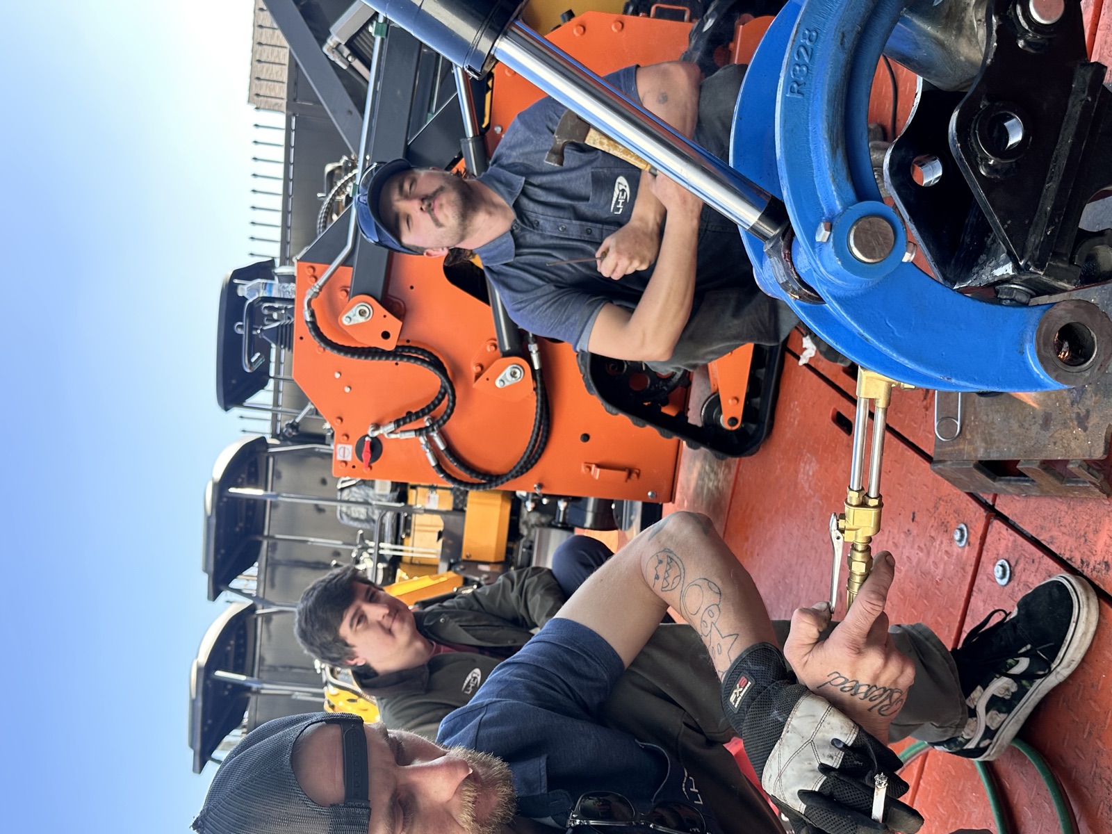 The crew gathered beside compact loaders