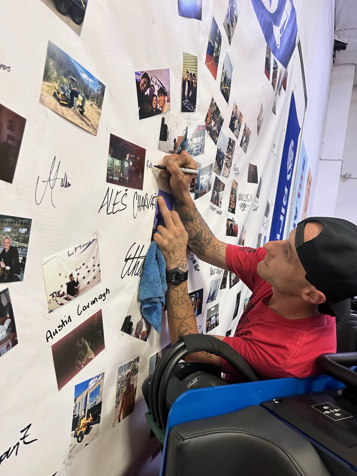 A team member signing the company photo wall